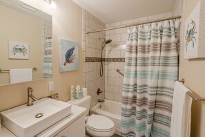 Un baño con lavamanos, inodoro y ducha.