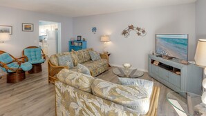 A living room with a sofa, chairs, a television, and a cabinet. - Beautiful Seashell/ Pool Star5vacations (Indian Shores)