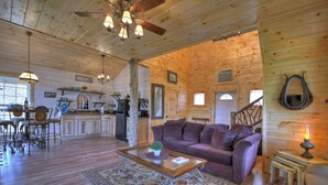 A wooden cabin interior with a dining area, kitchen, and living room. - Treehouse Ellijay Star5vacations (Ellijay)