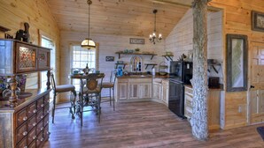 A wooden cabin interior with a kitchen, dining area, and a 'VACANCY' sign. - Treehouse Ellijay Star5vacations (Ellijay)
