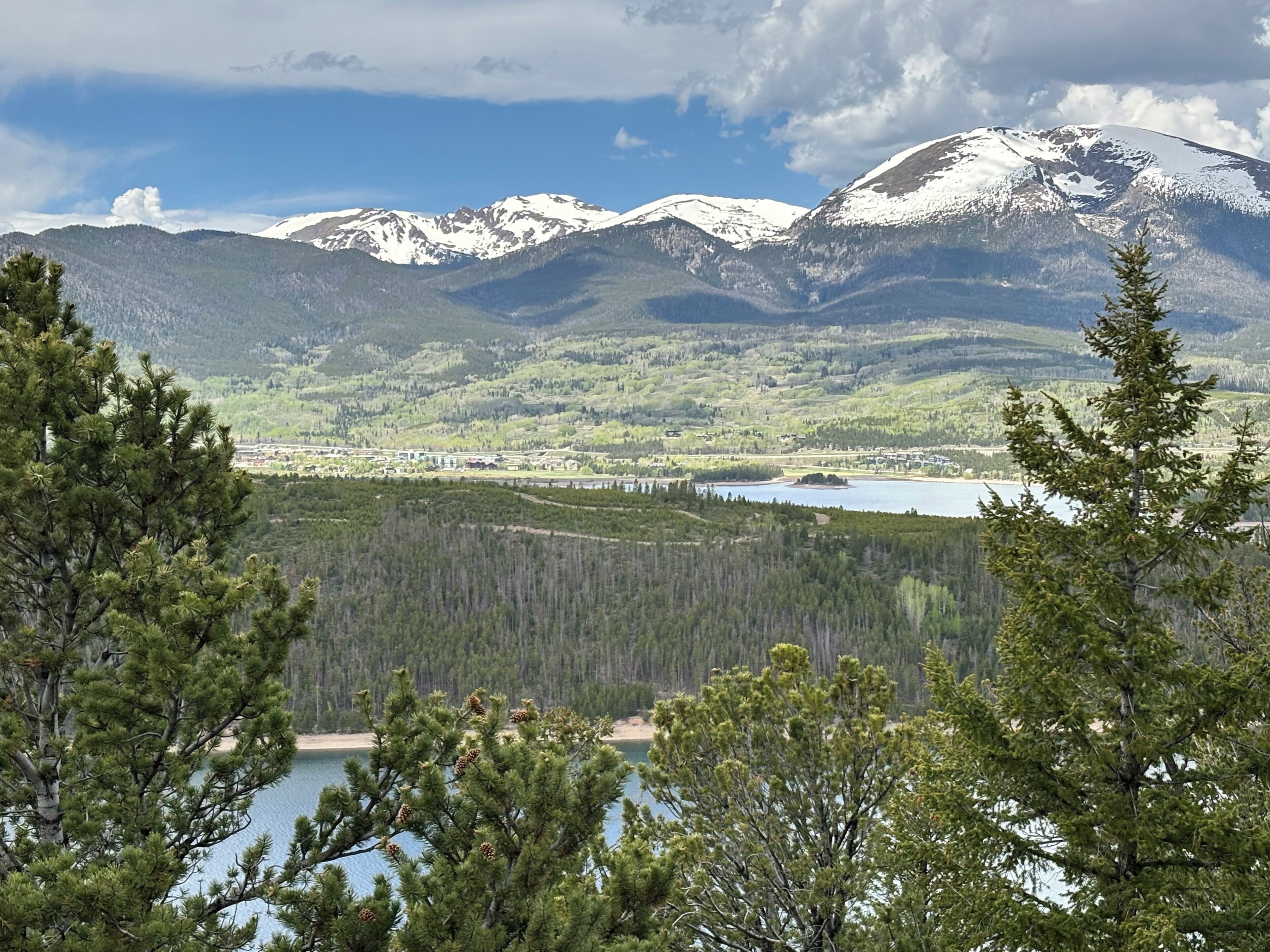 A mountainous landscape with a lake and forested area.