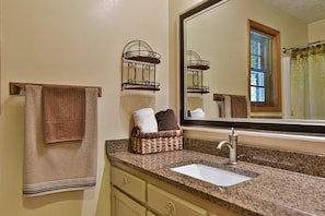 A bathroom with a sink, towel racks, and a mirror.