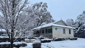 Een met sneeuw bedekt gebouw met een bord waarop 'MORTIMERS' staat.
