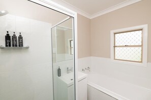 Bathtub, hair dryer, towels, shampoo