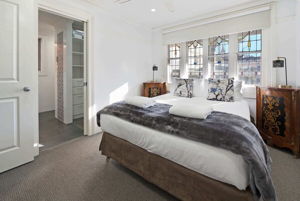A bedroom with a bed, a wardrobe, a nightstand, and a window with a view. - Blue Door Apartment 2 | CBD, Ideal for Work (Orange)