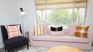 Ein Wohnzimmer mit einer Couch, einem Sessel und einer Lampe.