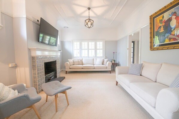 A living room with a fireplace, a sofa, a TV, and a painting on the wall.