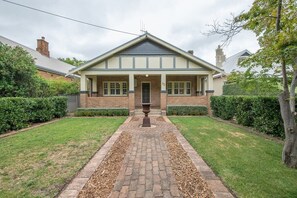 A two-story house with a front porch, brick exterior, and a number '92' on the front wall.
