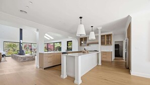 A spacious kitchen with a central island, pendant lighting, and a view of the outdoors.