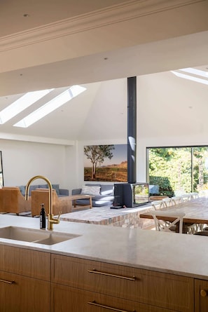 Una cocina moderna con tragaluces, chimenea y comedor con vistas al exterior.