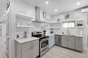 Una cocina moderna con gabinetes grises, un horno de acero inoxidable y un lavavajillas integrado.