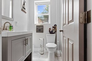 Une salle de bain moderne avec des toilettes, un lavabo et une fenêtre.