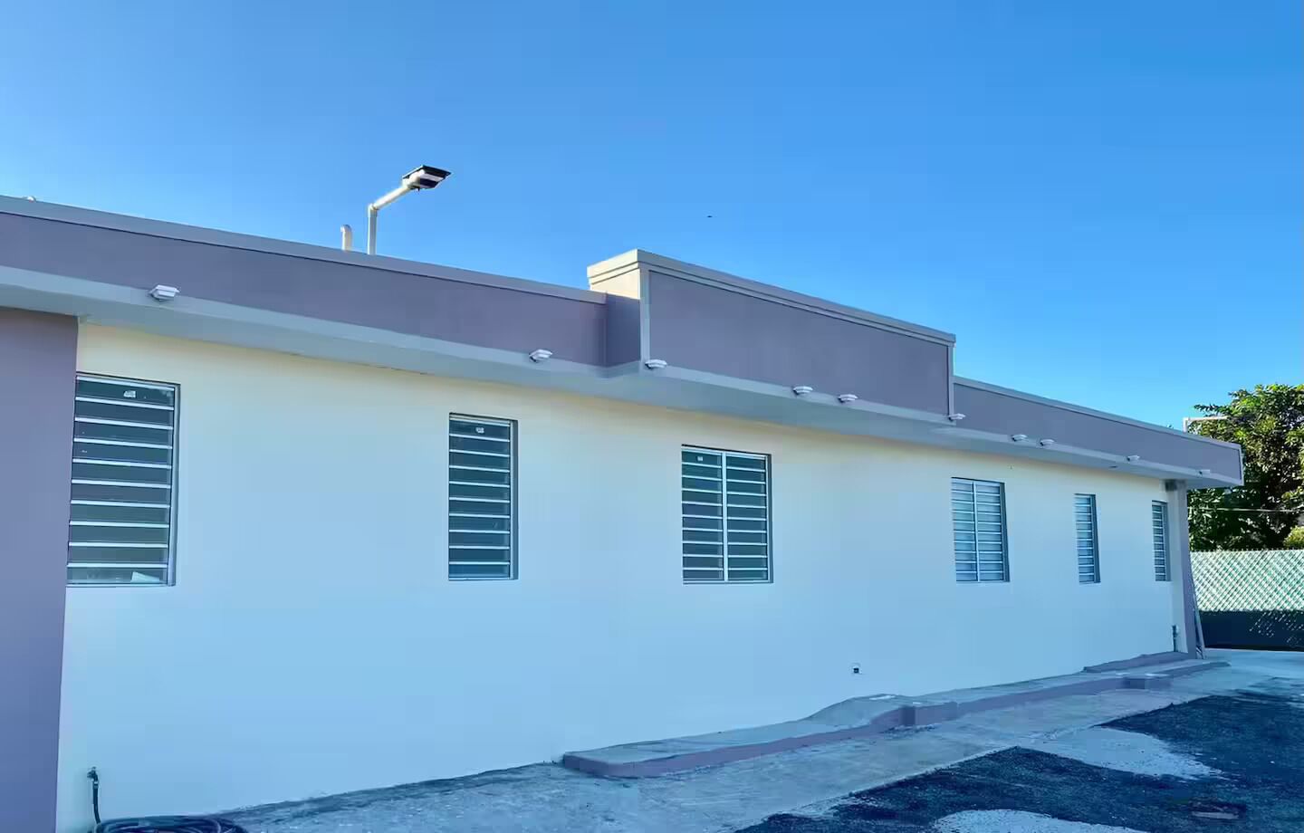 A modern building with multiple windows and a security camera.