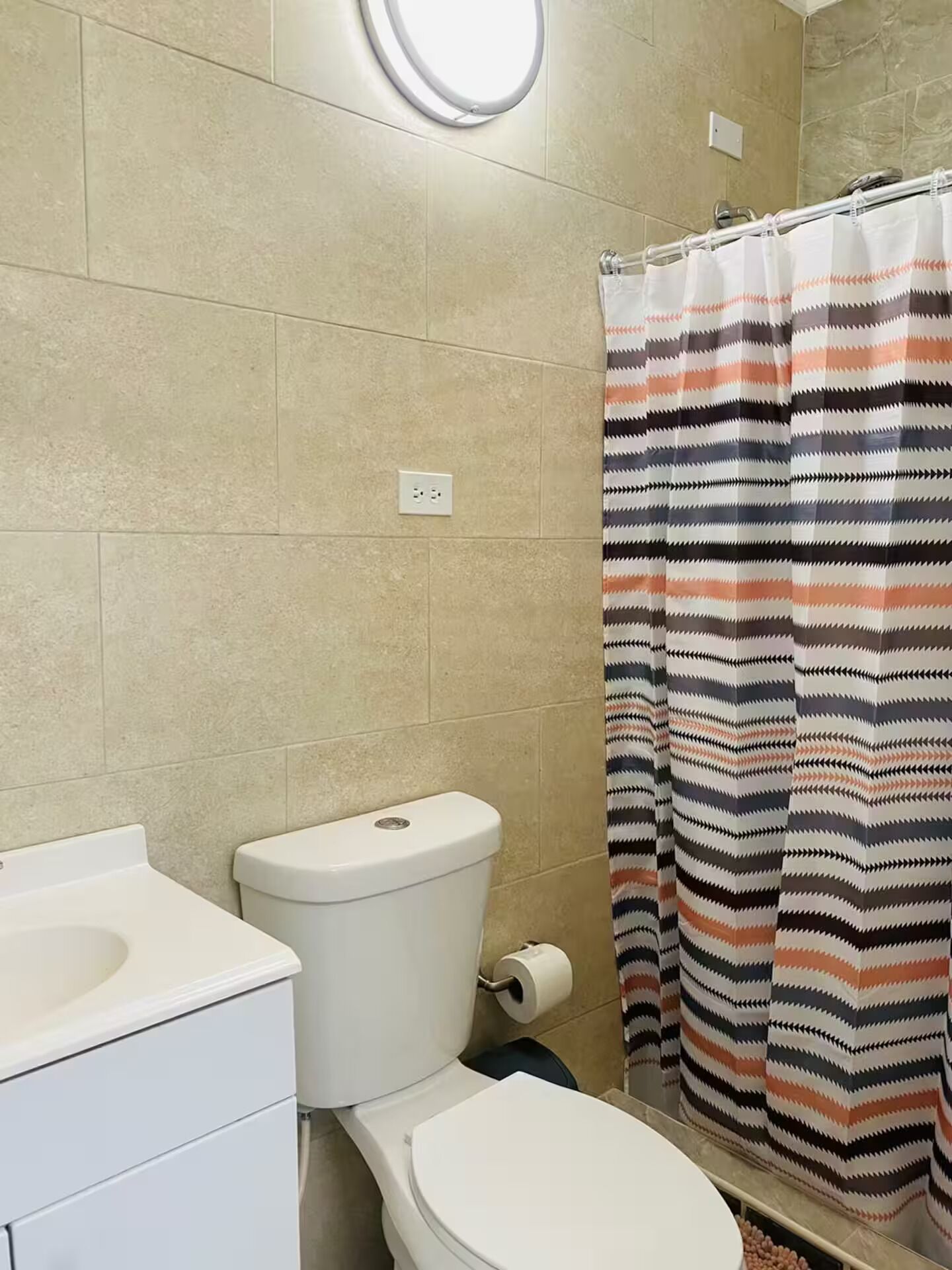 Une salle de bain équipée de toilettes, d’un lavabo et d’un rideau de douche.