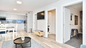Una cocina moderna con armarios blancos, un microondas integrado y una isla grande con asientos.