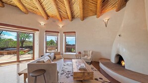A spacious living room with a fireplace, large windows, and a wooden ceiling. - Summer Pool, Hot Tub, Stunning Luxury (Santa Fe)