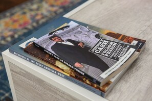 A stack of books with visible titles including "Backroads of the Great American West" and "Johnny Cash at Folsom Prison".