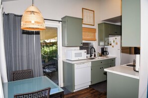 A compact kitchen with a dining area, featuring a microwave, coffee maker, and a small refrigerator. - Guesthouse in the heart of Historic Folsom (Folsom)