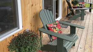 A wooden porch with two Adirondack chairs, a red bench, and a potted plant. - Baker cabin|Downtown Greenville-Moosehead Lake|WIFI|Pets Ok|2 cabins available (Greenville)