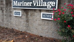 A sign for Mariner Village with house numbers 4747 and 4749.