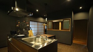 A modern kitchen with a central island, stainless steel sink, and a wooden countertop.
