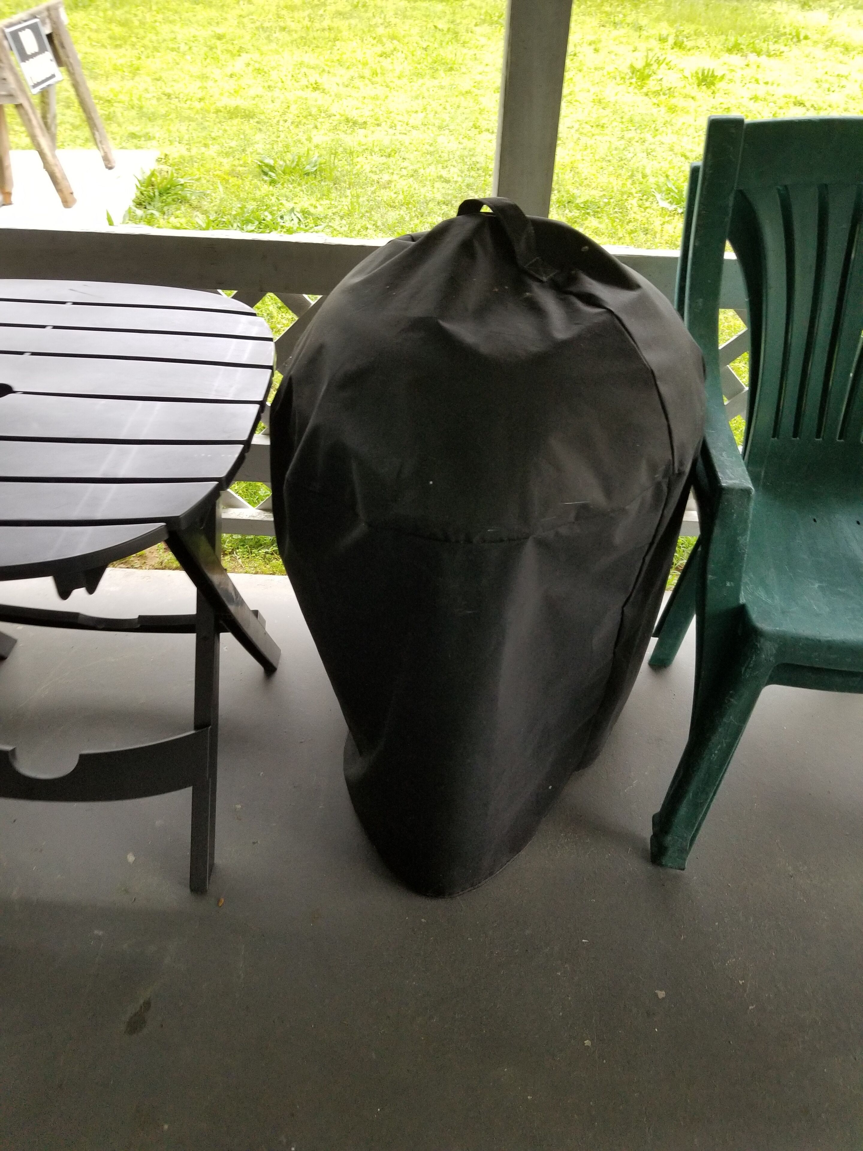 Un espacio al aire libre techado con una mesa y sillas.