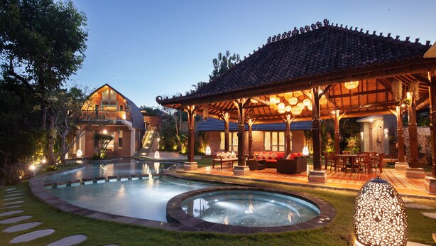 A resort with a swimming pool, outdoor seating, and a traditional building with a tiled roof. - Sunset Paradise Nusa Dua (Nusa Dua)