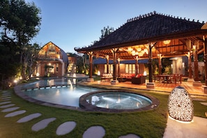 A resort with a swimming pool, outdoor seating, and a traditional building with a tiled roof. - Sunset Paradise Nusa Dua (Nusa Dua)