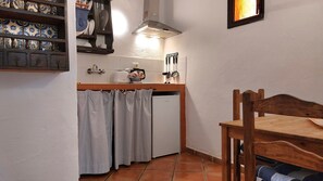A compact kitchen with a refrigerator, a stove, and a sink.