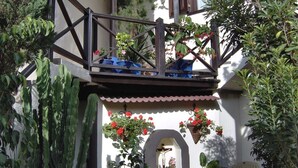 A balcony with potted plants and flowers, a wooden railing, and a small statue of Jesus Christ. - Single studio "Apartamentos Monasterio de San Antonio No. 5" with wifi and sea view - Adults only (Icod de los Vinos)
