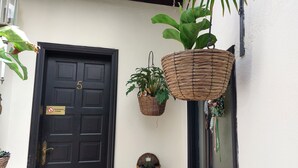 A black door with the number 5, a 'PROHIBIDO FUMAR' sign, and two hanging baskets with plants. - Single studio "Apartamentos Monasterio de San Antonio No. 5" with wifi and sea view - Adults only (Icod de los Vinos)