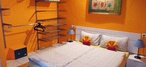 Een hotelkamer met een bed, twee bedlampen, een nachtkastje, een wandplank en een schilderij.