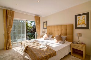 Un dormitorio con una cama grande, una mesita de noche, una ventana con cortinas y un cuadro en la pared.