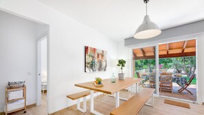 Une cuisine moderne avec une table en bois, des bancs et un luminaire suspendu.