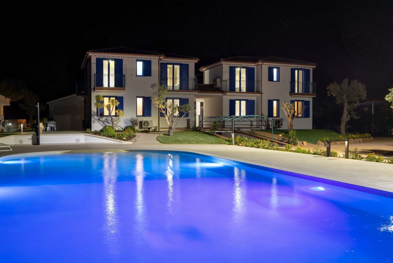 Un bâtiment à deux étages avec une piscine devant.