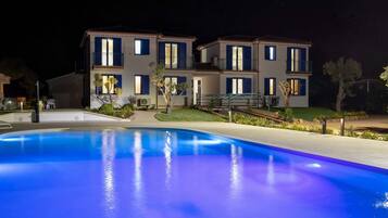 Un bâtiment à deux étages avec une piscine devant.