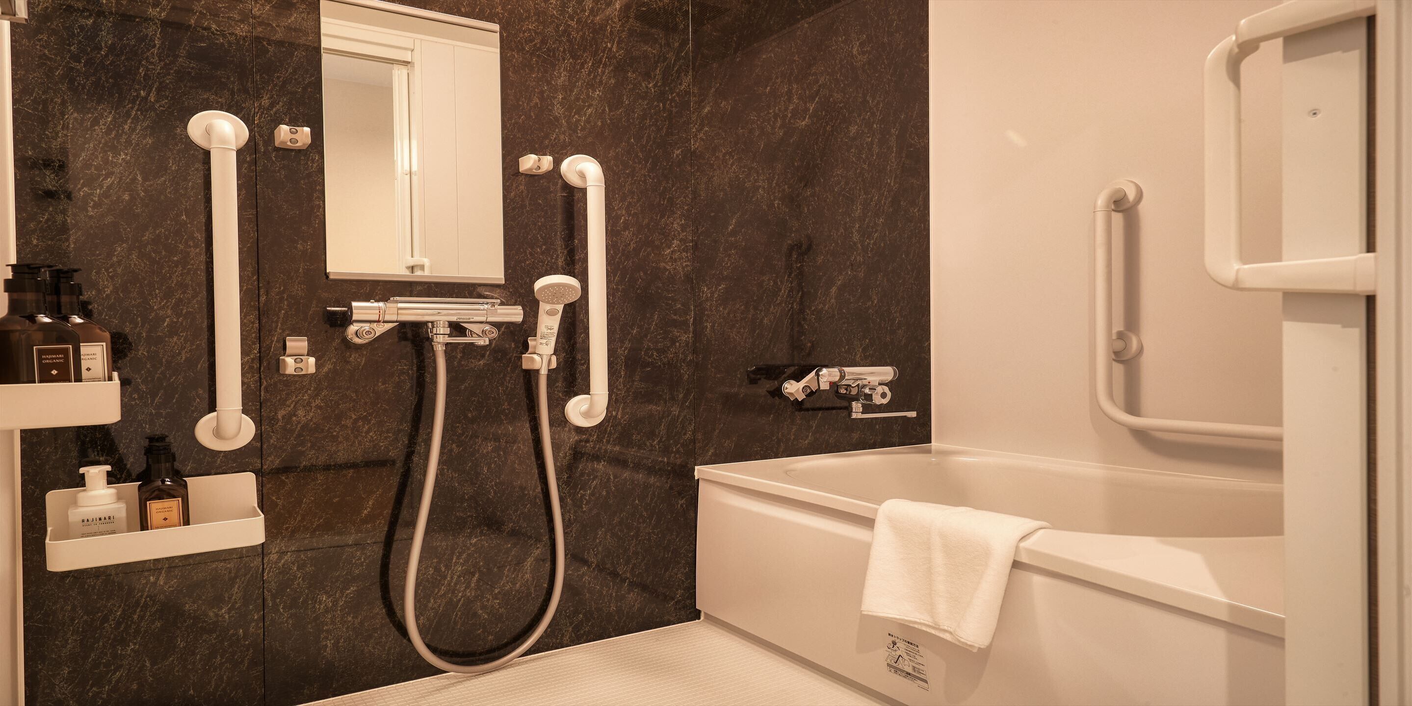 Un baño moderno con bañera, zona de ducha y tocador con artículos de aseo.