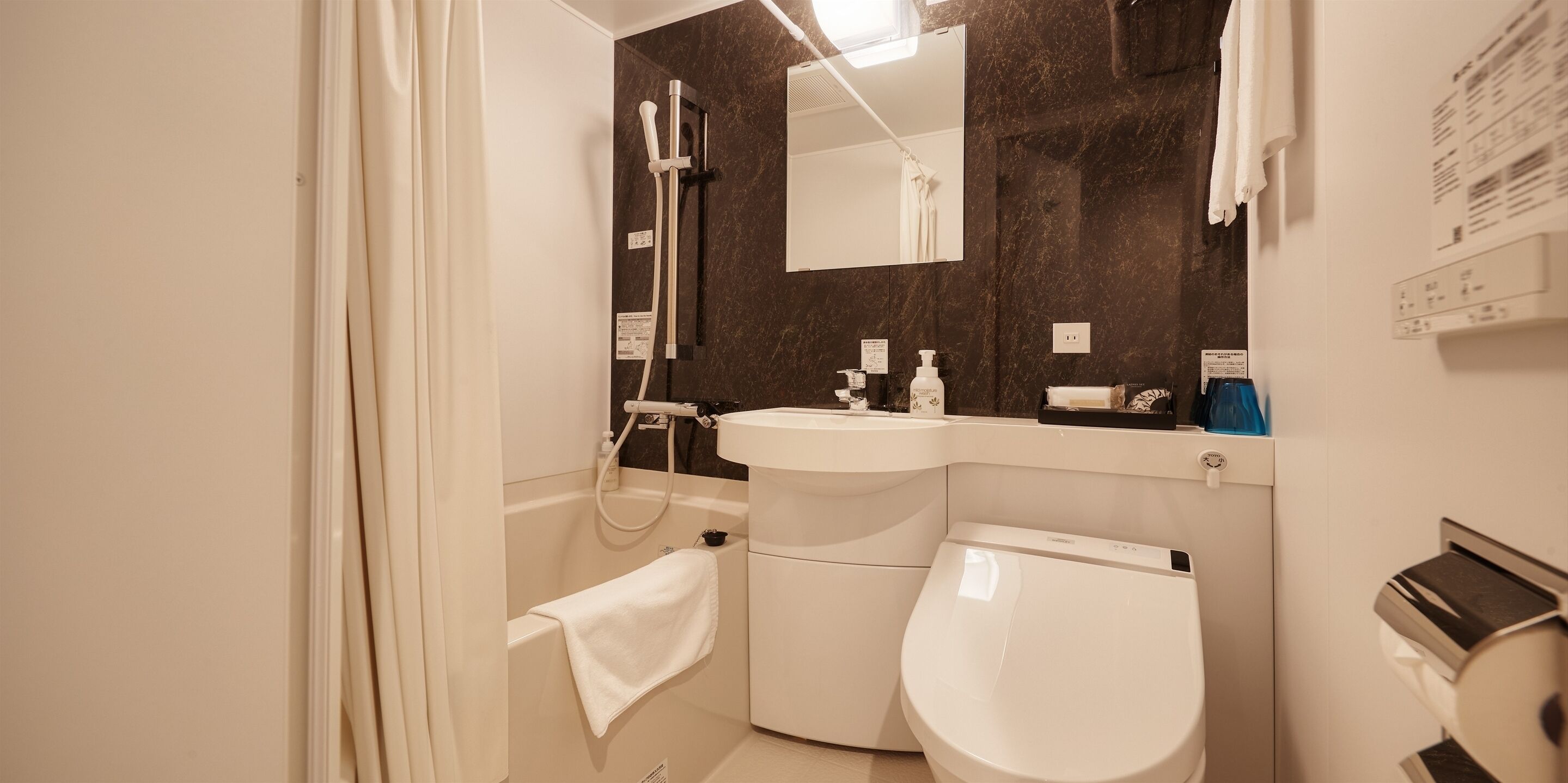 Ein modernes Badezimmer mit Badewanne, Toilette, Waschbecken und Dusche.