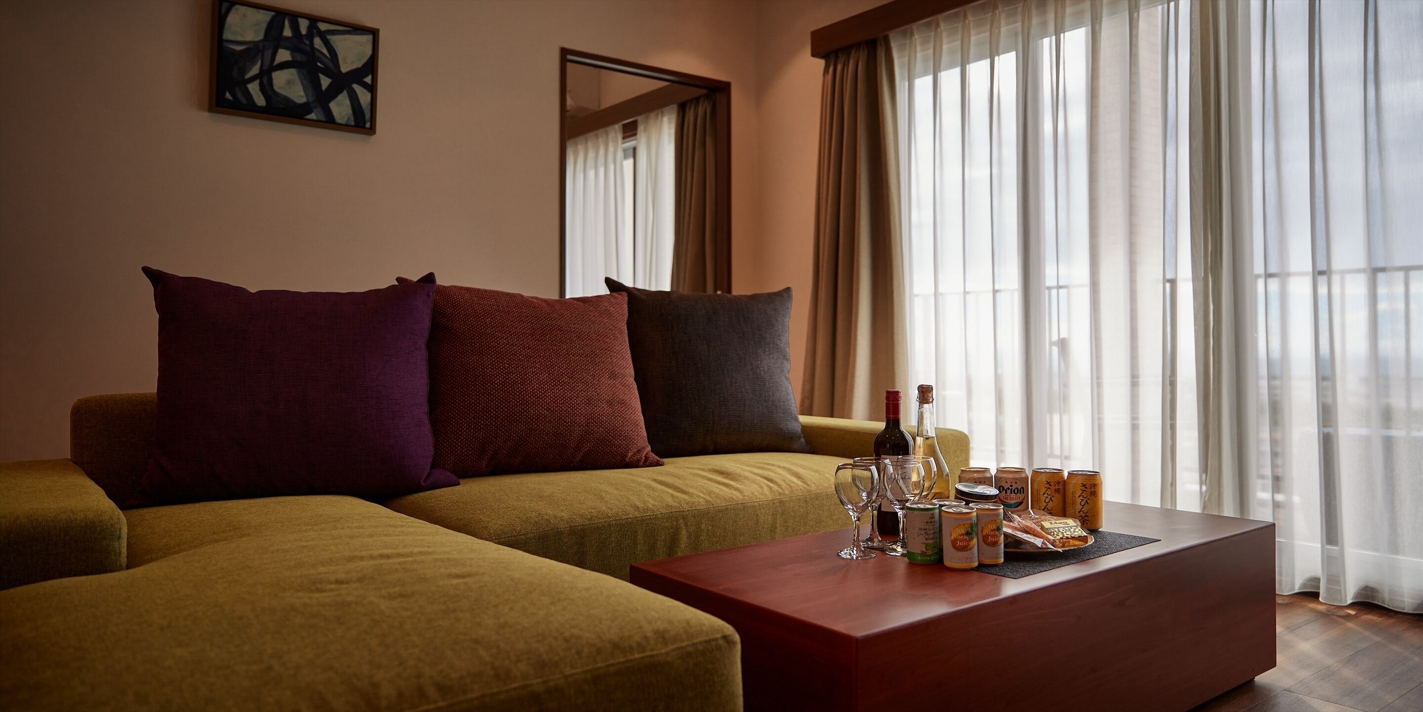 Una sala de estar con sofá, una mesa de centro y una ventana con cortinas.