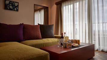 Una sala de estar con sofá, una mesa de centro y una ventana con cortinas.