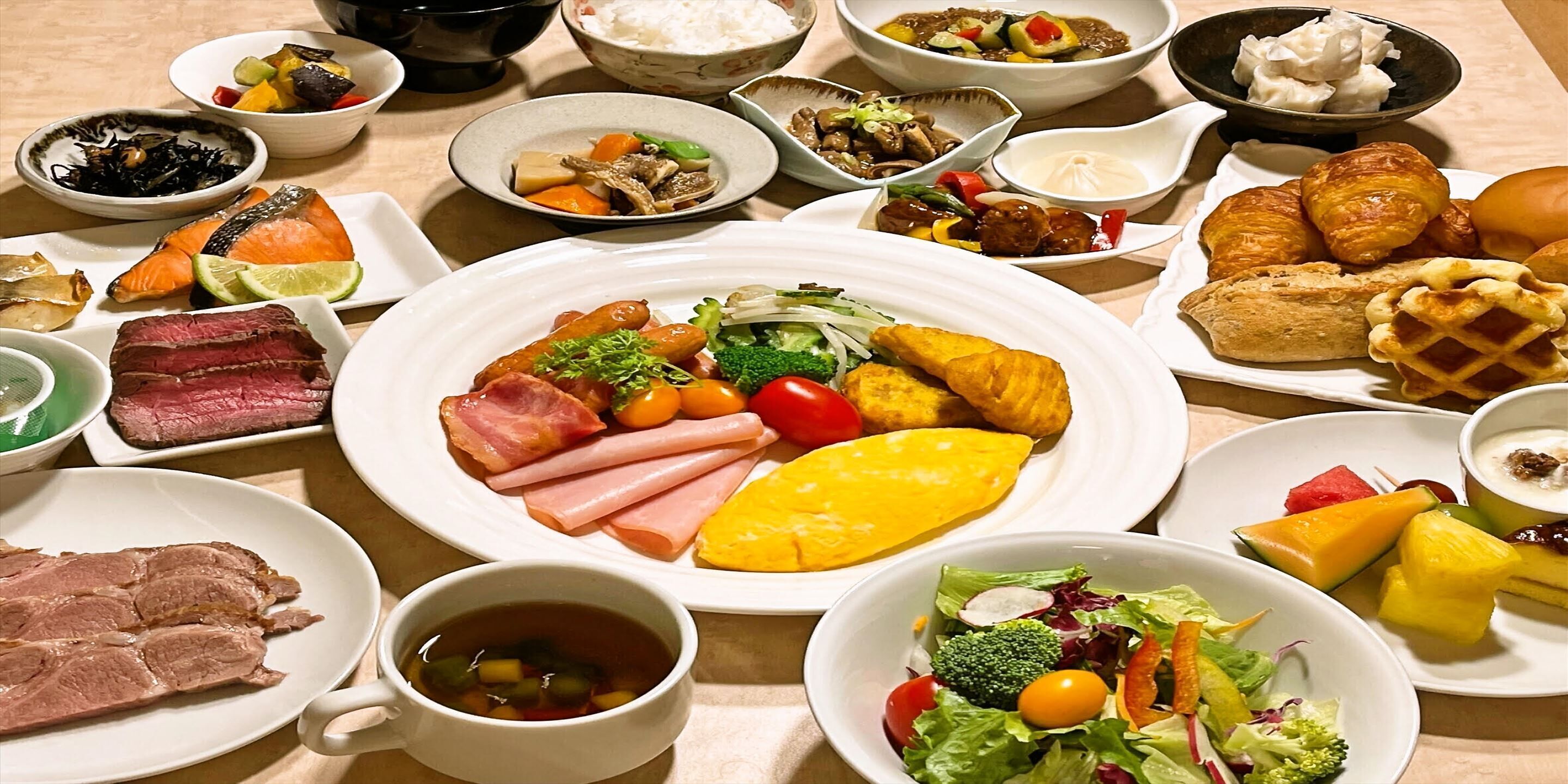 A variety of dishes including meat, vegetables, and pastries on a table.