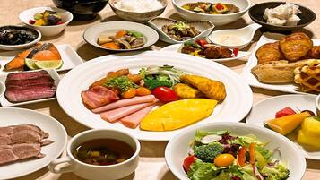 A variety of dishes including meat, vegetables, and pastries on a table.
