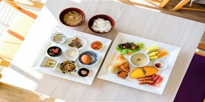 Una mesa con varios platos, entre ellos arroz, sopa y verduras.