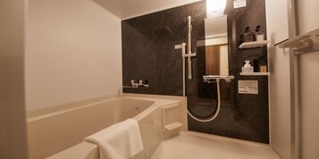 Un baño moderno con bañera, cabina de ducha y estante empotrado con artículos de aseo.