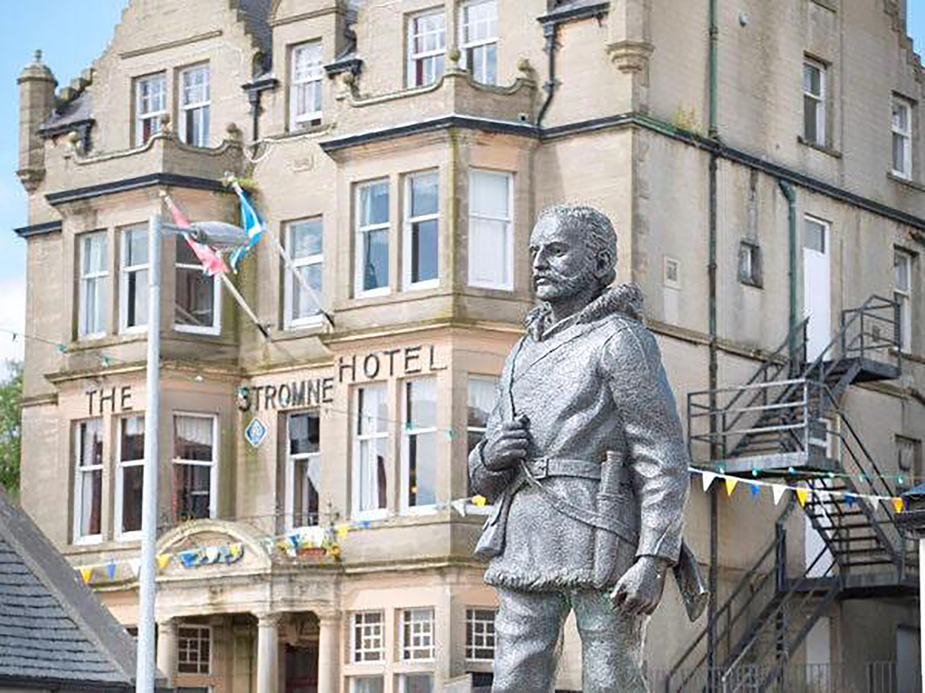 A statue of a historical figure in front of The Stronne Hotel.