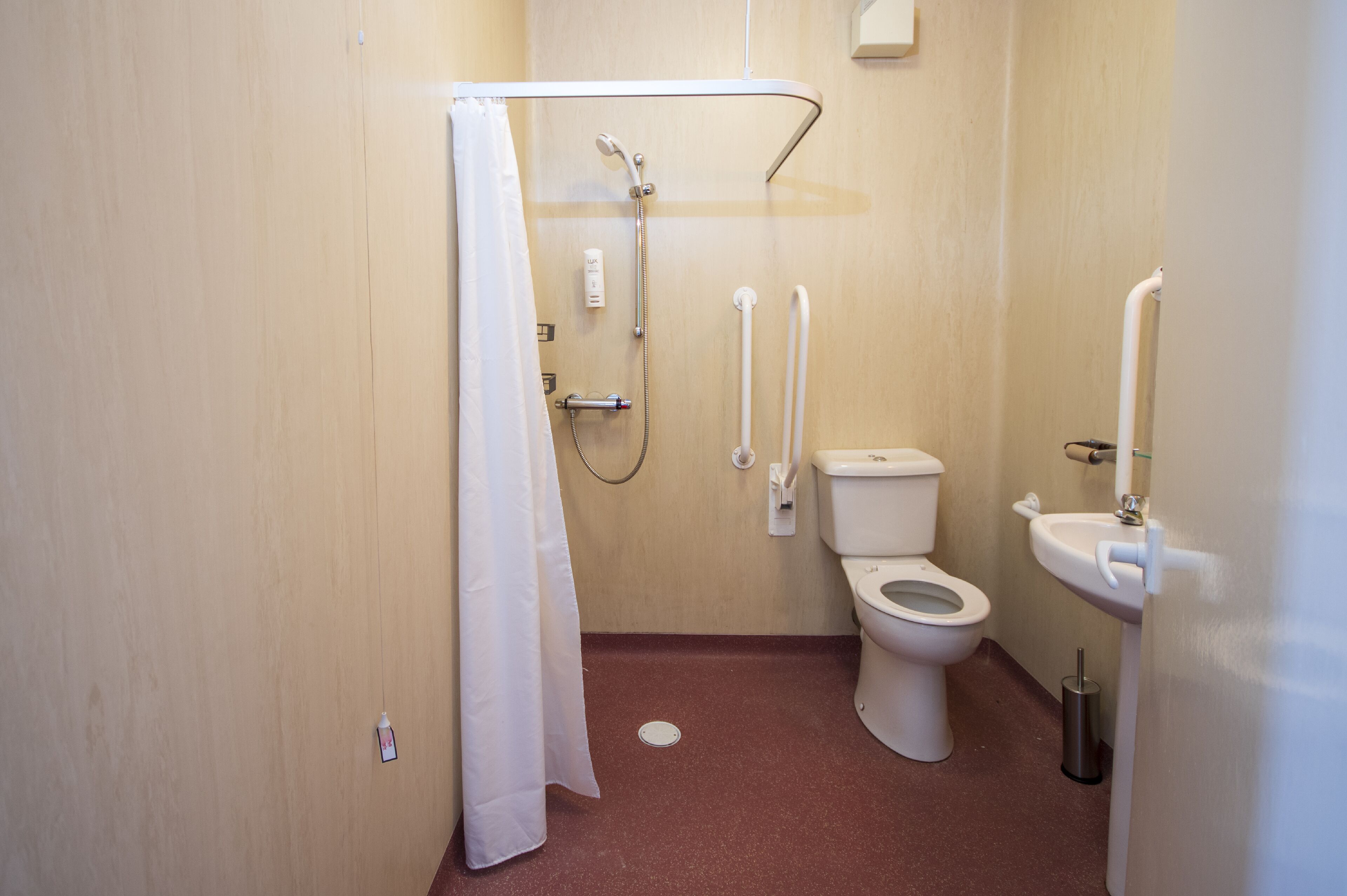 Une petite salle de bain avec une douche, des toilettes et un lavabo.