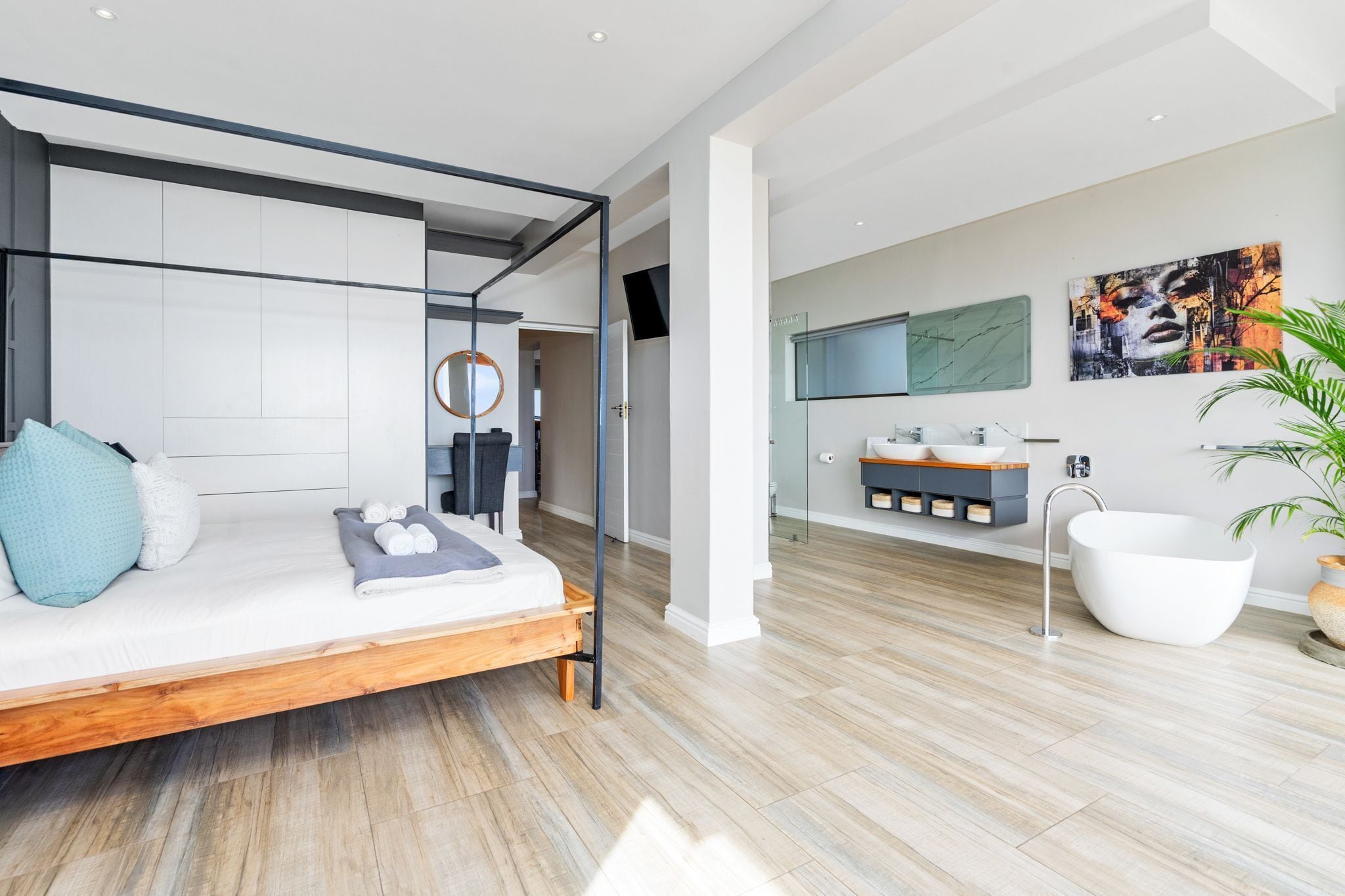 Un dormitorio moderno con cama, mesita de noche y un amplio ventanal.