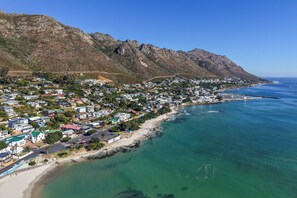 Un pueblo costero con playa, casas y montañas.