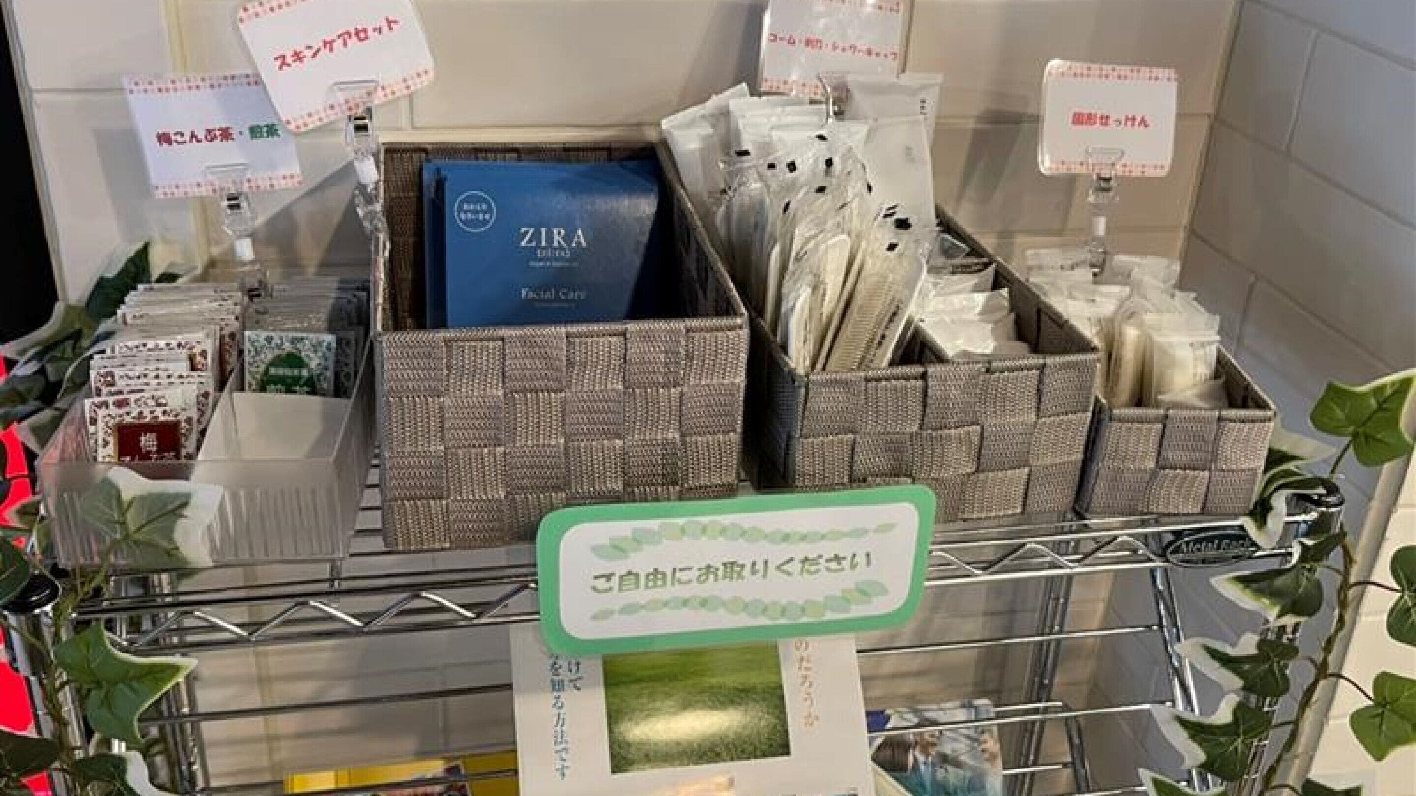 Ein Verkaufsdisplay mit verschiedenen Produkten, darunter eine blaue Schachtel mit dem Aufdruck 'ZIRA' und mehrere Körbe mit Waren.