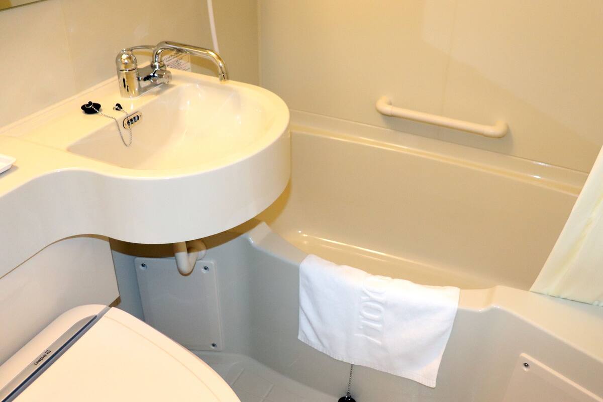 Een badkamer met een witte wastafel, een bad en een toilet.